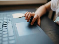 Auto-Generate PDFs in Make Child interacting with a laptop touchpad while sitting at a table