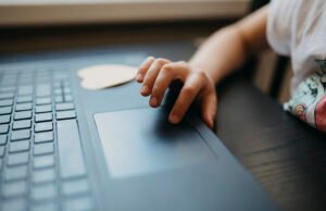 Auto-Generate PDFs in Make Child interacting with a laptop touchpad while sitting at a table