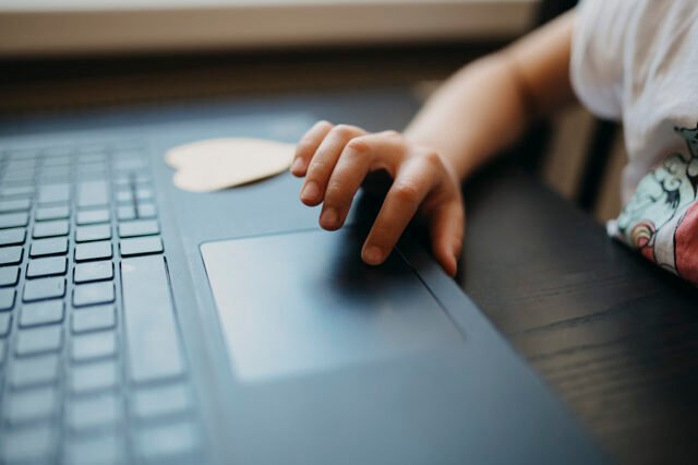 Auto-Generate PDFs in Make Child interacting with a laptop touchpad while sitting at a table