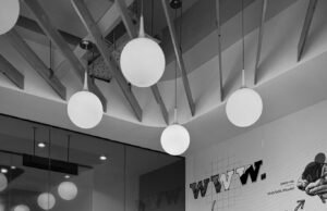 How to Hire a Webflow Designer in 2026: Costs, Where to Look, and How to Vet Minimalist workspace with a large screen, tripods, web design graphics, and pendant lights.